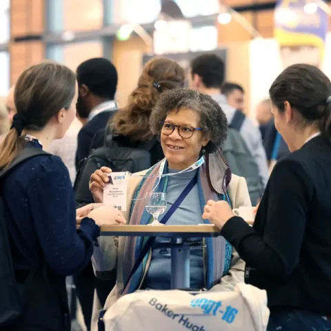 Woman smiling and talking at event. GHGT-16