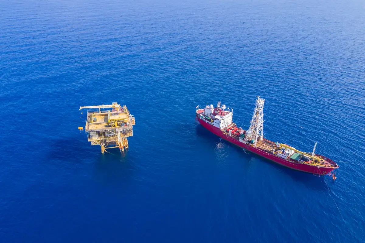 Ship near oilrig with blue ocean sea and sky